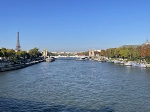 Paysage urbain parisien classique montrant le pont Alexandre III, la Seine et la tour Eiffel avec le Grand Palais en arrière-plan.
