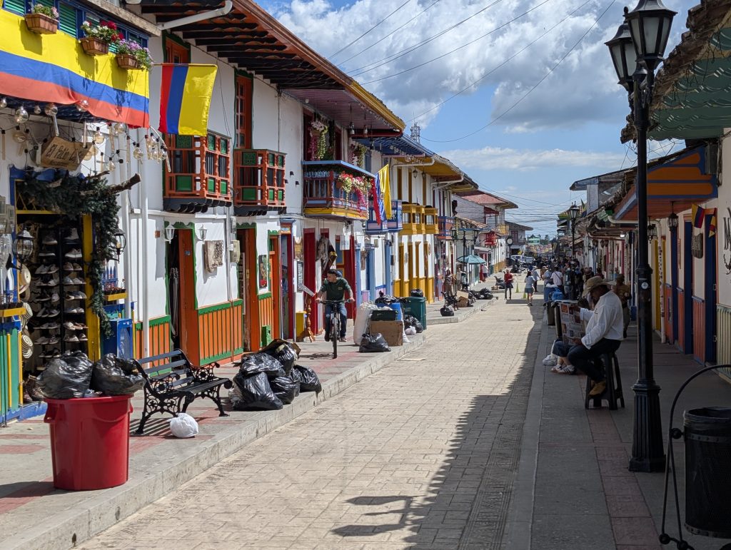 Farbenfrohe Straße in Salento mit Holzbalkonen und kolumbianischen Flaggen