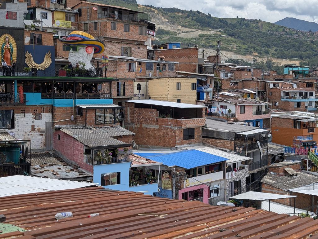 Bunte Backsteinhäuser, die sich an den Hang der Comuna 13 in Medellín schmiegen